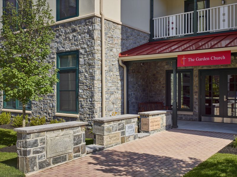 A stone walkway and the glass door entrance to a church